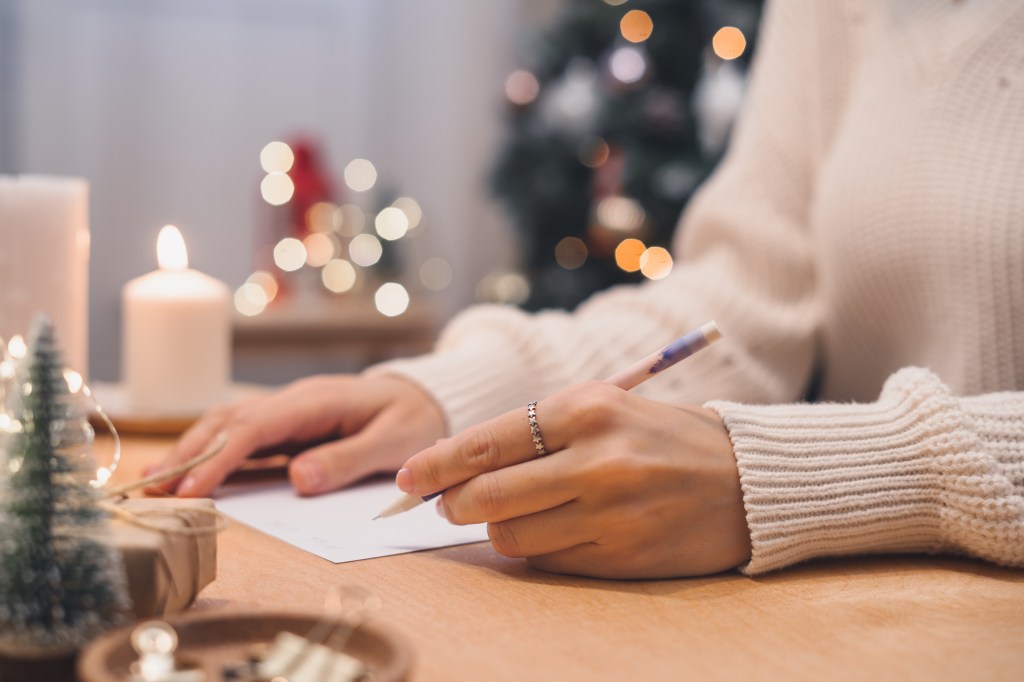 A woman writing Christmas cards. 