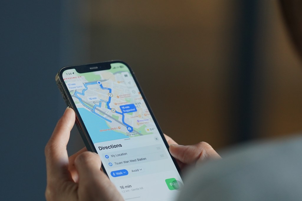 Woman using Google Maps app on her smartphone to plan route